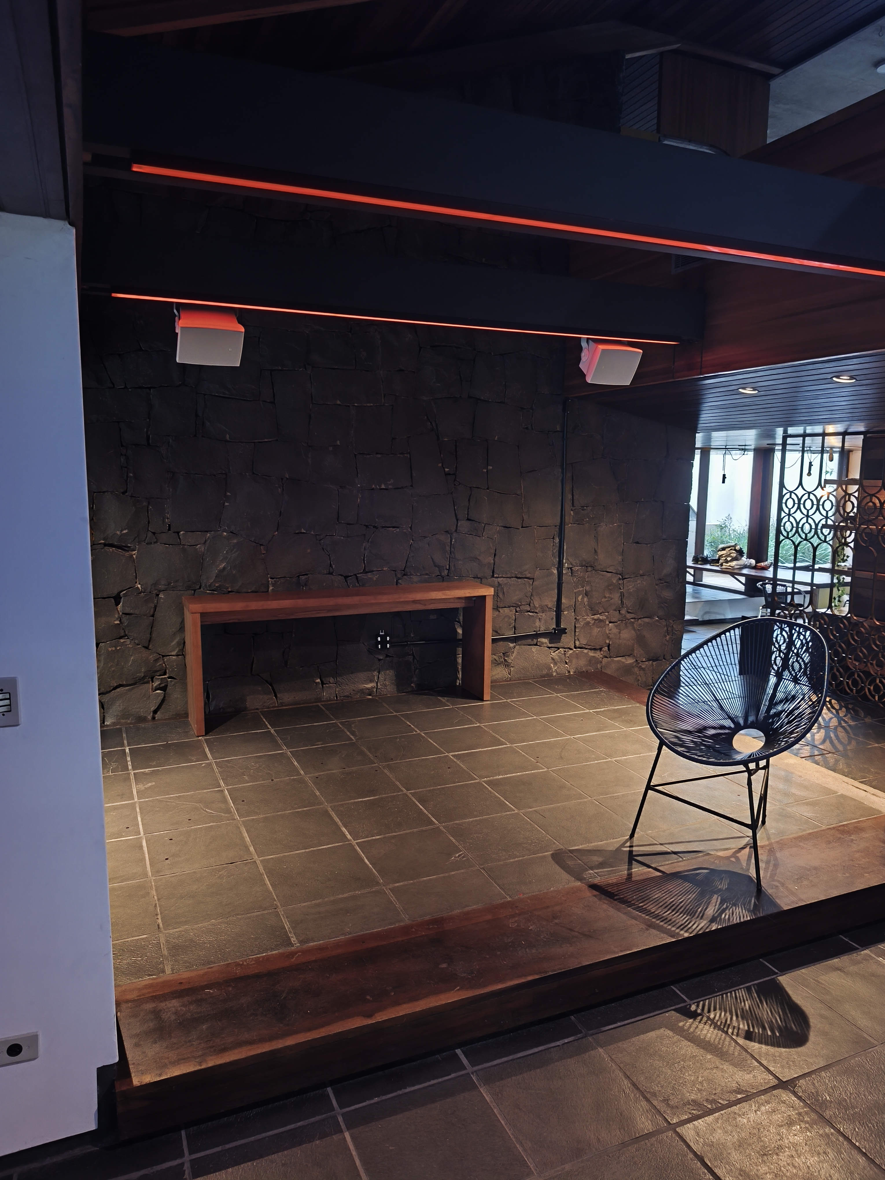 Projeto de iluminação cênica com LED vermelho em ambiente rústico